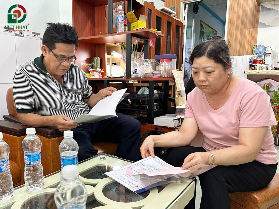 Hình ảnh gia đình Anh Thi kiểm tra hợp đồng trước khi ký kết